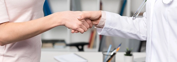 Close-up of a patient and healthcare provider shaking hands